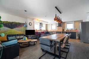 a kitchen and living room with a table and chairs at Guesthouse Eindeloos in 't Zand - North Holland in 't Zand +46 photos