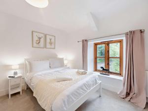 a white bedroom with a bed and a window at 4 Bed in Ilfracombe oc-95899 in Berrynarbor
