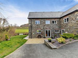 a stone house with a driveway in front of it at 2 Bed in Llanidloes oc-95815 in Llanidloes