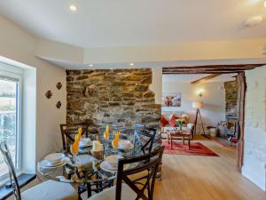 a dining room and living room with a stone wall at 2 Bed in Llanidloes oc-95815 in Llanidloes