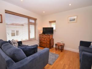 a living room with two blue couches and a television at 2 Bed in Brixham oc-bx054 in Brixham