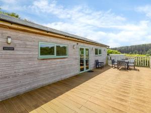 a house with a deck with a table and chairs at 1 Bed in Ilfracombe oc-parsc in Berrynarbor