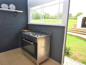 a stove in a small kitchen with a window at 1 Bed in Llandysul oc-85415 in Rhyd Owen