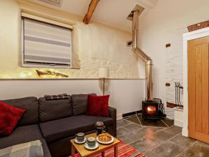 a living room with a couch and a wood stove at 2 Bed in South Molton oc-55221 in Bishops Nympton