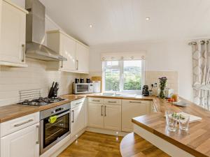 a kitchen with white cabinets and a stove top oven at 2 Bed in Okehampton oc-74242 in Okehampton
