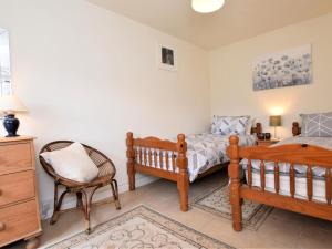 a bedroom with two beds and a chair at 2 Bed in Tiverton oc-shayn in Huntsham
