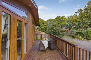 a wooden deck with a table and chairs on it at 2 Bed in Okehampton oc-85432 in Okehampton