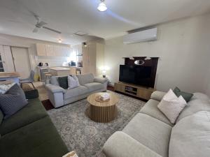 a living room with two couches and a tv at Cosy Heritage Cottage in Ararat