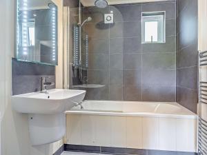 a bathroom with a sink and a bath tub at 2 Bed in Conwy oc-50284 in Llangelynin +6 photos