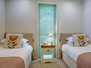 a bedroom with two beds and a table with a lamp at 2 Bed in Conwy oc-50284 in Llangelynin