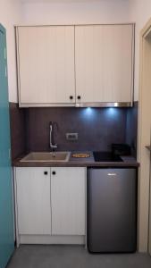 a kitchen with white cabinets and a sink at Casa Elezi in Koufonisia