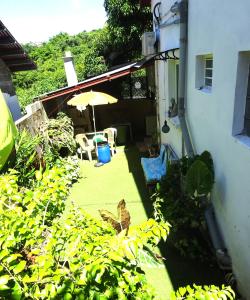 a patio with an umbrella and chairs and a butterfly at Le coin tranquille in Saint-Denis