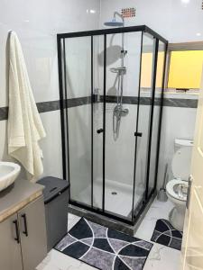 a bathroom with a glass shower with a toilet at Nkambo Apartments in Kitwe +5 photos