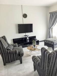 a living room with two chairs and a table at Nkambo Apartments in Kitwe