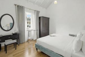a bedroom with a bed and a vanity and a mirror at Aadya Tea Bungalows by Aahaasa in Hatton +73 photos