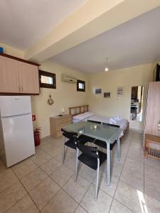 a kitchen and living room with a table and a refrigerator at Sea Nest Studio 1 in Agia Ermioni