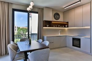 a kitchen with a table and chairs and a dining room at Poljana Olive Homes Pool Residences in Rijeka Reževići