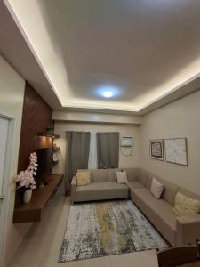 a living room with a couch and a tv at Avida Storeys 2 7th Floor in Iloilo City