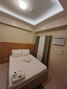 a small room with a bed with towels on it at Avida Storeys 2 7th Floor in Iloilo City
