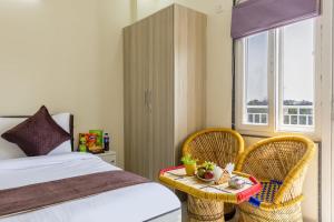 a bedroom with a bed and two chairs and a table at Expressway Hotel - Yashobhoomi, Dwarka in New Delhi