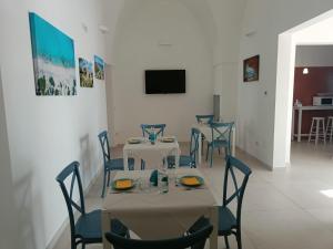 a dining room with two tables and blue chairs at B&B Benefici in Maruggio