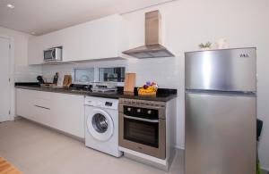 a kitchen with a stainless steel refrigerator and a dishwasher at Cityscape Views - New 2BR Retreat in Asunción
