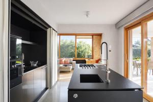 a kitchen with a black counter top and a living room at Pool Villa Lazise in Lazise