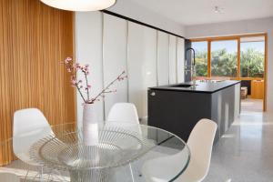 a dining room with a glass table and white chairs at Pool Villa Lazise in Lazise