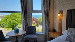 a hotel room with a view of a bed and a window at Geckos Rest in Newquay