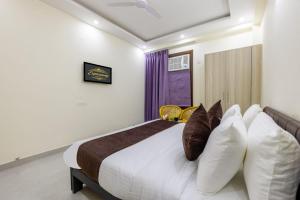 a bedroom with a large bed with pillows at Expressway Hotel - Yashobhoomi, Dwarka in New Delhi