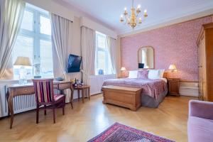 a bedroom with a bed and a desk and a chair at Grand Hotel Lund in Lund +94 photos
