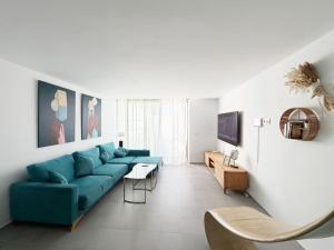 ein Wohnzimmer mit einem blauen Sofa und einem Tisch in der Unterkunft VILA TABARCA QUALITY & LUXURY in Tabarca