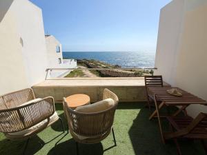 ein Balkon mit Stühlen und einem Tisch und das Meer in der Unterkunft VILA TABARCA QUALITY & LUXURY in Tabarca