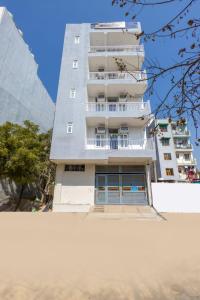 a tall white apartment building with a balcony at Expressway Hotel - Yashobhoomi, Dwarka in New Delhi