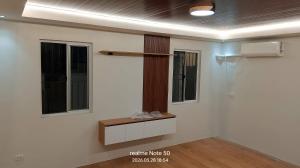 ein Zimmer mit zwei Fenstern und einer weißen Wand in der Unterkunft Casa Matiu in Antipolo