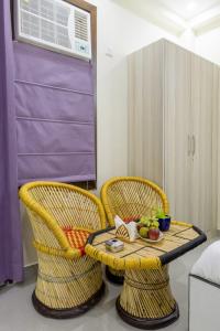 two chairs and a table with a bowl of fruit at Expressway Hotel - Yashobhoomi, Dwarka in New Delhi