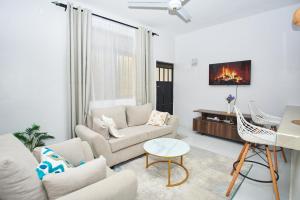 a living room with a couch and a tv at Diani Dream stays 2 in Diani Beach