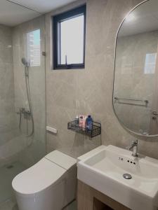 a bathroom with a toilet and a sink and a mirror at KSWL Residence in Long Bình