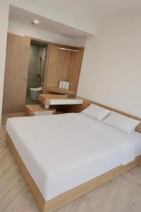 a bedroom with a large white bed and a bathroom at KSWL Residence in Long Bình