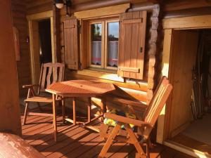 a wooden table and chairs on the porch of a cabin at Blockhaus Noffke in Stamsried