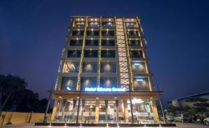 a tall building with lights on it at night at HOTEL SILVERA GRAND in Ahmedabad
