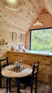 a wooden cabin with a table and chairs and a bed at Le Moulin de Trévelo in Caden