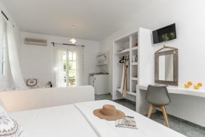 a white bedroom with a white tub and a chair at Palatiana Agriturismo-Philoxenia Cottages Retreat in Galini