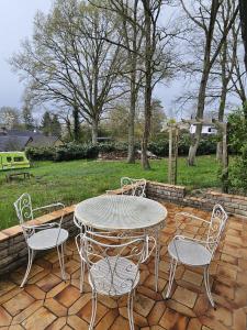 Ein Tisch und Stühle stehen auf einer Ziegelterrasse in der Unterkunft Forest Mood in Braine-le-Château