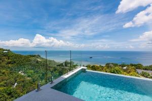 a swimming pool with a view of the ocean at Shamgrila - Panoramic Sea View in Ko Phangan