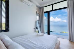 a bedroom with a bed and a view of the ocean at Shamgrila - Panoramic Sea View in Ko Phangan +46 photos