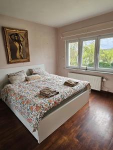 ein Schlafzimmer mit einem Bett und zwei Fenstern in der Unterkunft Forest Mood in Braine-le-Château