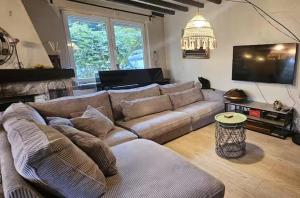 ein Wohnzimmer mit Sofa und Flachbildfernseher in der Unterkunft Forest Mood in Braine-le-Château