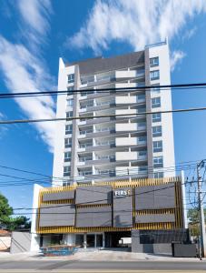 a tall white building with yellow accents at Cityscape Views - New 2BR Retreat in Asunción