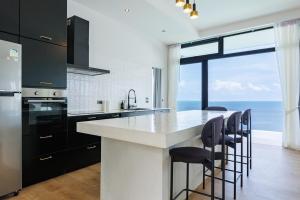 a kitchen with a large island with black and white appliances at Shamgrila - Panoramic Sea View in Ko Phangan